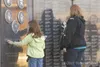 Shannon Moody and her daughter Lia, 7, touch the Veterans' Wall
of Honor after attending the September 11 ceremony Sunday morning.
(ROBERT DeBERRY/Frontiersman) Robert DeBerry