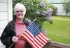 Matanuska Valley Colonist Gerry Keeling stands outside the Colony House Museum in Palmer with a 48-star American flag, a piece that reminds her of the Alaska she knew before statehood. CAITLI