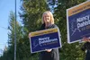 Lt. Gov. Nancy Dahlstrom, a Republican U.S. House candidate, holds a campaign sign at an Eagle River intersection on Aug. 20, 2024, Alaska’s primary election day. With her are several sign-wa