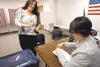 Erin Adkins jokes with election worker Barbara Hernandez as she casts an early ballot in August 2012 at the division of elections on Bogard Road. In Palmer, early voters need to visit the Mat