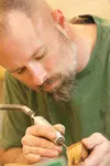 Tracy Fowler cleans up a wooden shrimp at his shop in the
Valley. Fowler is teaching a intro to wood power carving March 10,
from 9 to 5 p.m. For more information or to register for a class
c