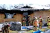 Firefighters stand near a home that burned on Monday near Meadow Lakes. The house, which belonged to a Houston firefighter, was a total loss. No one was injured, but a house cat perished in t