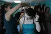 Alissa Brotherwood, left, helps fellow Burchell High School student Autumn Dawn try on a necklace to match her new prom dress at a mini boutique set up in the school on Wednesday, March 23. B