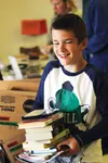 Ryan Littau, 10, leaves the Friends of Wasilla Library used book sale with an armload of books on Friday, Sept. 11, 2015. Littau and his family said they attend the twice-a-year sales at the 