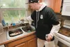 Chris Giles demonstrates that when the water faucett is turned on, the spray nozzle begins to leak. They have to keep a bucket under the sink to keep water from leaking out of the light fixtu