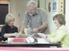 Diana Dollerhide, Willet Bushnell and Ida McMahon cross-check a
report printed from one of two Accu-Vote machines used to tally the
questioned and absentee votes at Sunday's vote count. Photo