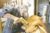 ROBERT DeBERRY/Frontiersman Leather worker and saddle maker
Michael Sturgeon screws part of a custom saddle to a saddle tree at
his Palmer shop.