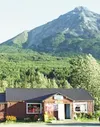 King Mountain and the Matanuska River provide the scenic
backdrop for a lodge believed to be the Glenn Highway's oldest
continuously operating lodge still in its original building. Photo
by E