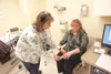 ROBERT DeBERRY/Frontiersman Nurse Lorrie Dreese attaches a heart
rate monitor to the finger of Mat-Su Valley Frontiersman Publisher
Kari Sleight Friday during her pre-Trim to Win physical.
