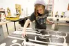 Palmer High School student Genna Woody applies ink to a wood block carving during last week’s steamroller project at PHS. The art project was a collaboration of Palmer, Wasilla and Colony hig