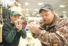ROBERT DeBERRY/Frontiersman Sportsman’s Warehouse employee
Charles West, left, gets a duck call lesson from Wasilla resident
Keith Maurer at the store’s Saturday grand opening.