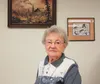 Eugenia "Gena" Straayer sits in front of her husband Jack's painting, hung on the wall of her cubicle at Mat-Su Senior Services. Gena celebrated her 90th birthday last week on New Year's Eve,