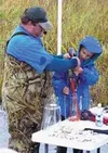 Mason Minturn, a third-grader at Butte Elementary, helps take
the eggs from a female coho salmon Monday at Spring Creek. Photo by
CASEY RESSLER/Frontiersman.