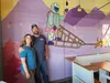Lisa and Robert Brown pose for a photo in front of a colorful painting done by former employee Payton Miller. Jacob Mann/Frontiersman