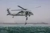 Soldiers with the 5th Special Forces Group (Airborne) utilize a rope latter to climb up to a U.S. Navy MH-60S Seahawk, during Helocast training. Helocasting is an airborne technique used by s