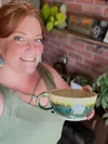 Amanda Graydon, owner of the Wandering Café, shows off a locally crafted ceramic mug on display and for sale at the Wasilla restaurant. Courtesy of Wandering Café