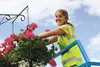 Amy Borg, with the city of Wasilla Parks and Public Works Beautification Crew, waters the hanging baskets along Swanson Avenue Thursday afternoon. She said the baskets require daily watering.