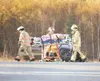 ROBERT DeBERRY/Frontiersman Members of the Central Mat-Su Fire
Department move the injured driver of a mini van to a waiting
ambulance Thursday morning on the Palmer-Wasilla Highway. The
high