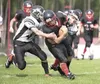 Houston Hawk quarterback Nai Saechao pushes for more yardage on a quarterback keeper as a pair of Valdez Buccaneers complete the tackle during the second half of Saturday's game at Houston Hi
