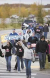 Walkers hold signs as they cross Hermon Road Thursday afternoon.
The group of close to 100 participants are taking part in a United
Way health walk that started at Target and goes to Sears an