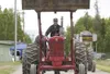 Antique Power Club member Allan Dubord raises the bucket on his
1953 International Farmall Model-M tractor as he drives in the
tractor procession before the start of the tractor pull at
Satur