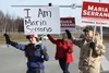 District 3 Mat-Su Borough Assembly candidate Maria Serrano waves to passing cars with her mother, Beverly, and her father, Gil, at the intersection of Fern Street and Knik-Goose Bay Road at a