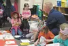 Eric Vogel, of the US Coast Guard, right, helped Swanson Elementary students mark Dr. Seuss’ birthday March 2 by handing out presents for the students. Above left, Briel Glanville opens up he