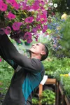 Mid-Valley Garden and Greenhouse owner Mark Oathout checks on a hanging basket Saturday morning. ROBERT DeBERRY/Frontiersman.com