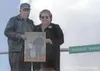 James Sr. and Wanda Rowland stand near Rowland Memorial Way in
Palmer in May holding a photograph of their son, James Rowland Jr.,
with his son. Rowland Jr. was shot and killed in the line of