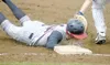 JEREMIAH BARTZ/Frontiersman Alaska’s Eli Graber slides back into
first base under the tag during a 10-2 loss to the Chugiak Mustangs
on Saturday at Lou McManus Field.