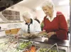 ROBERT DeBERRY/Frontiersman Patty Hendrickson, left, and Vivian
Giroux work thier way around the salad bar Monday during lunch time
at the Palmer Senior Center. The center provides 250 meals 