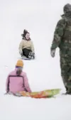 ROBERT DeBERRY/Frontiersman Grace and Mike Brown watch as
Savannah Brown, 13, hits the long run-out at the bottom of the big
sledding hill at Crevasse Moraine Trail System on Saturday
afterno