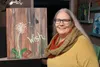 Local painter and Artists Uncorked owner Becky Oviatt stands in front of an original work of art hanging up in downtown Palmer. Jacob Mann/Frontiersman.com