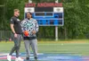 Chris Kuper and Junior Aumavae stand at the middle of the field as players arrive for the final day of the Solstice Lineman Camp. J. David McChesney/Frontiersman