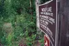 A dented sign is the only thing separating the stand of woods in the Wolf Lake State Recreation Site from the surrounding woods. Wolf Lake was among a handful of sites that were “de-parked” i