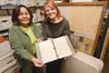 Volunteer Doris Anderson and Houston City Clerk Sonya Dukes hold a hand-written book of meeting minutes dated from 1966 to 1969 that was damaged when the records room at Houston City Hall was