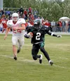Colony running back Randale Harvey scampers away from Wasilla
nose guard Jed Wade on a 10-yard gain late in the first quarter of
the Knights' 35-21 win over the Warriors at Colony High School
