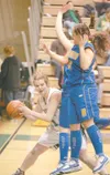 ROBERT DeBERRY/Frontiersman Colony forward Alex Coon passes
around two Kodiak players during a win over the Bears earlier this
year.