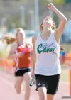 Colony anchor leg runner Sydney Stewart raises her hand in
victory Saturday afternoon after beating Wasilla’s Alison Kelley
across the finish line of the 3200-meter relay event at the
Norther