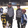 Carl Brent and Carl Brent Jr. hold a pre-game discussion with
team captains before the start of a recent squirt hockey game at
Brett Memorial Ice Arena. Photo courtesy of Anna Brodt