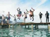 The boys leap for life into the warm Caribbean. They are, from left, Everette Evanoff, Dawson King, Chris Kopy, teacher Joe Dinwiddie, David Cordero, Hamza Dorsey, Judah Bang and Tito, a fish