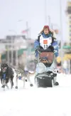 Four time Iditarod champion Martin Buser along with his
Iditarider make their way along Fourth Avenue Saturday in Anchorage
during the ceremonial start of the Iditarod Trail Sled Dog Race.
RO