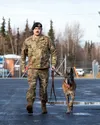 U.S. Air Force Staff Sgt. Scott Brakefield, a military working dog handler with the 673d Security Forces, escorts his retired military working dog Dino during his final walk at Joint Base Elm