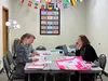 Birgit Meany, the ESL teacher at Nine Star Mat-Su, works with 2 students to improve their English Language skills