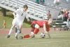 ROBERT DeBERRY/Frontiersman Wasilla Warrior Dustin Hout looses
his footing as Colony senior Tim Jaronik puts the pressure on for
the ball Saturday at Palmer High School during the Northern Li
