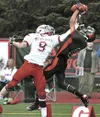 Juneau-Douglas’ Aquino Brinson catches a touchdown pass while being defended by Wasilla’s Brendin Featherstone during the Crimson Bears’ 69-30 win over the Warriors last Saturday night at Ada