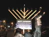 Ken Goldman of Kenneth Goldman Law Offices lights the first candle of the Menorah last week in Palmer. Courtesy of Rabbi Mendy Greenberg