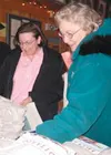 Iditarod volunteers Caroline McRoberts of Wasilla and Jan
Pelrine of Eagle River choose their souvenir volunteer T-shirts.
Photo by STEVE KADEL/Frontiersman.