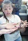 Randi Smith holds a leopard frog named J.J. and stares at a
bumble bee frog being held by teacher Deb Petersen. The Associated
General Contractors of Alaska feel that projects like Deb
Peters