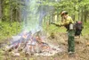 AMIE PAPPAS/Frontiersman Gannette Glacier fire crewman Richard
Harrop throws a spruce bough on a fire during a fuel reduction burn
at Pioneer Park Elementary School on Wednesday.